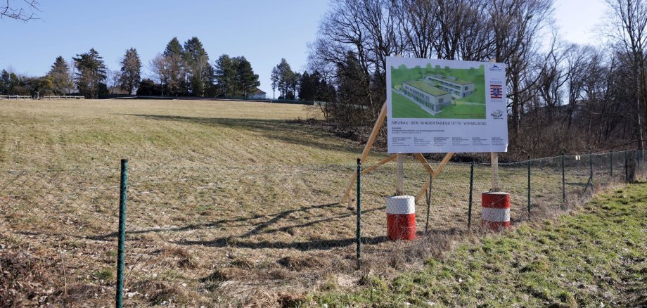 Schild Neubau Kindergarten Wirbelwind mit Bauplatz im Hintergrund